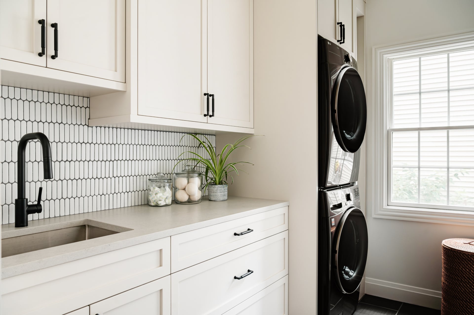 Laundry room with picket tile, custom cabinetry and stacked machines in an Elmhurst, IL home by Dara Agruss Design