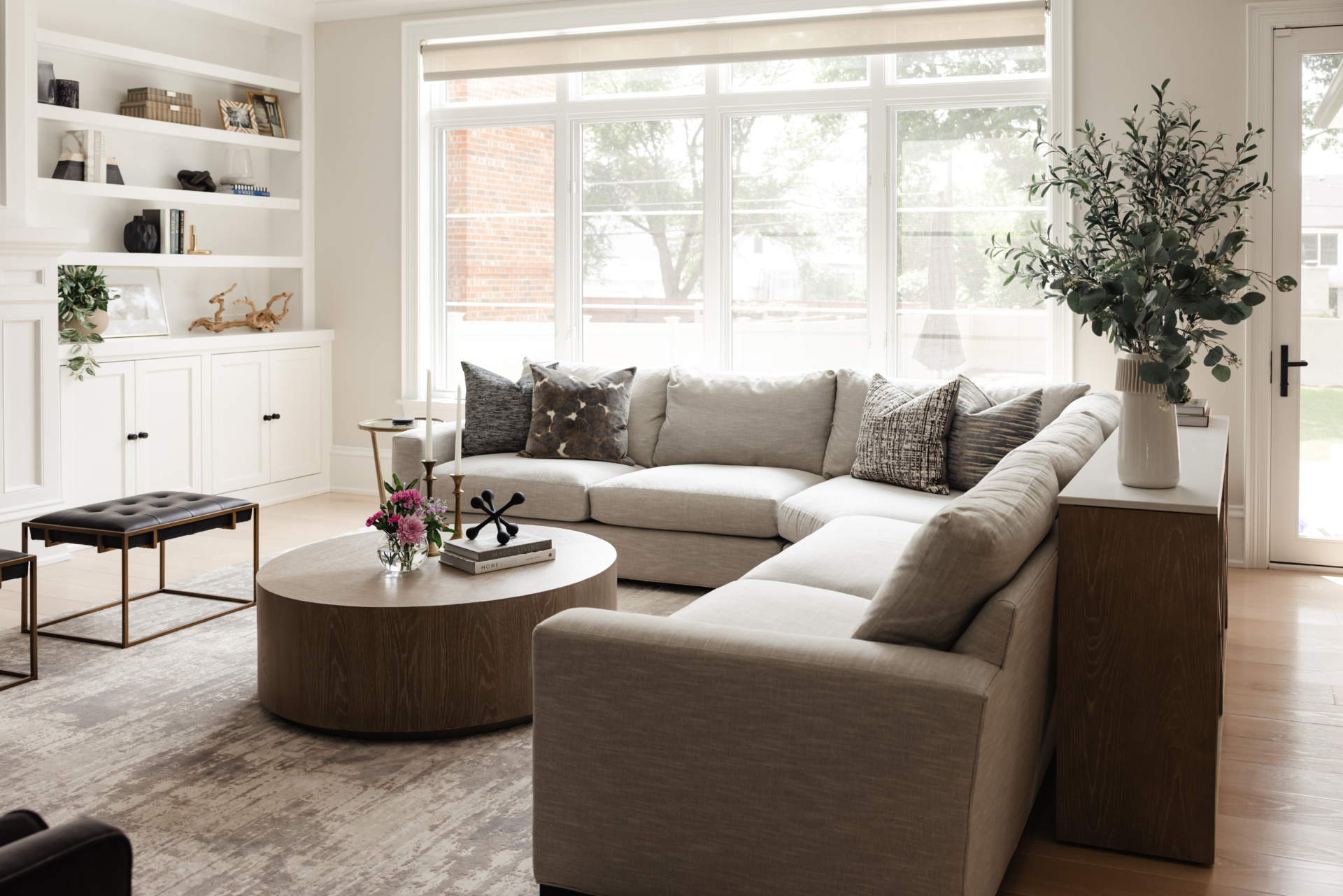Living room with a linen sectional, round coffee table and layered textiles in an Elmhurst, IL home by Dara Agruss Design