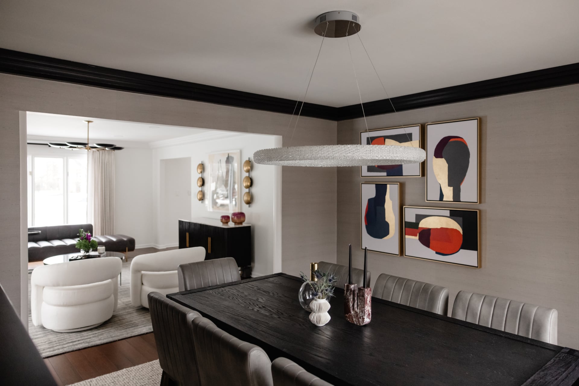 Dining room with a dark wood table, ring chandelier and abstract triptych in an Oak Brook, IL home by Dara Agruss Design
