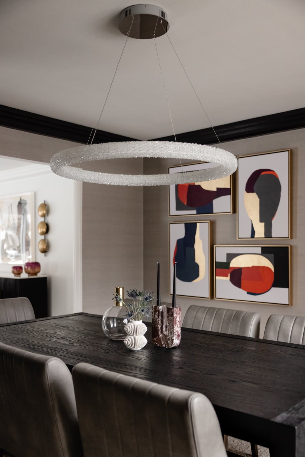 Dining room with a linear ring chandelier and upholstered chairs in an Oak Brook, IL home by Dara Agruss Design