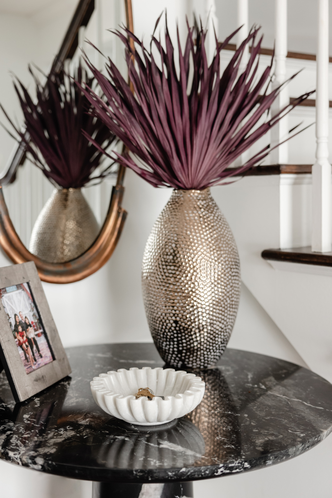 Console detail with sculptural brass vases and dried florals in an Oak Brook, IL entry by Dara Agruss Design