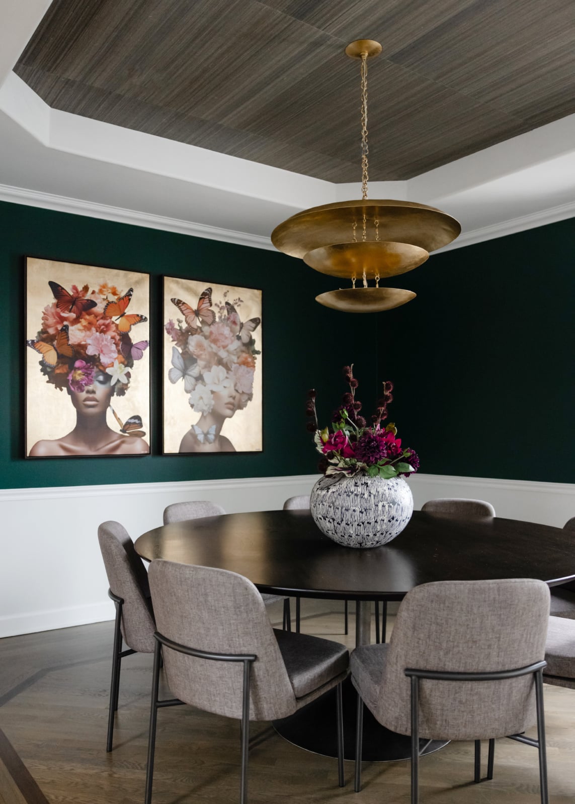 Dining room with deep green walls, a brass pendant and a round table, designed by Dara Agruss Design