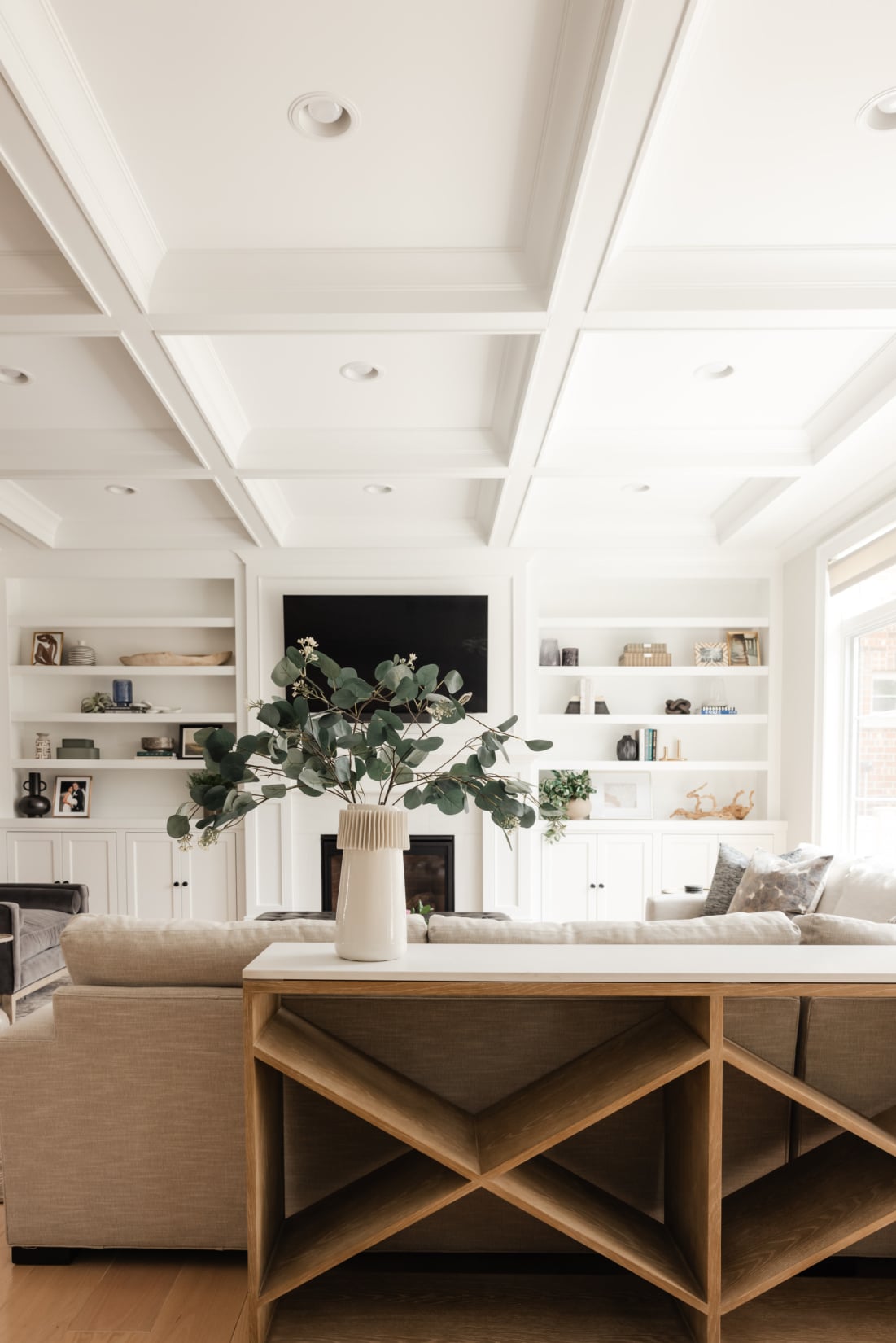 White built-in shelving styled with books, objects and a large eucalyptus arrangement