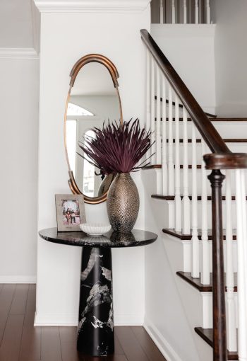 Shiny Vase On A Black Table Next To Stairs