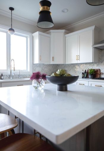 Close-up of large kitchen island with white quartz countertops